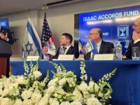 Conferencia de Isaac Accords Fund con autoridades y banderas en una mesa con arreglos florales
